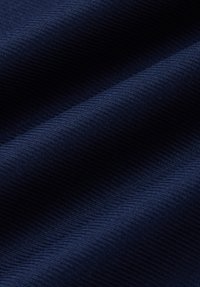 Granatowa tkanina o fakturze prążkowanej, ukazująca gładkie fale i fałdy, sugerujące średnią wagę i układ materiału.