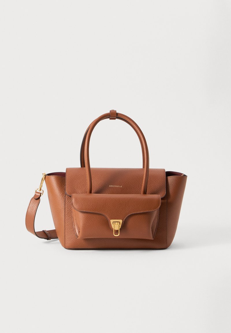 Ruskea nahkalaukku, jossa on rakenteellinen muotoilu, yläkannatin, irrotettava olkahihna, etupussikappale ja kullansävyinen varustus.