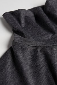 Ciemnoszary materiał o miękkiej, teksturowanej powierzchni, z marszczonym dekoltem i drapowanymi fałdami, tworzącymi swobodny wygląd.