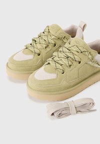 Groene suede sneakers met netaccenten, beige rubberen zolen en gepatteerde veters. Inclusief een extra paar beige veters.