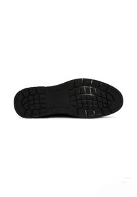 Suela de zapato de goma negra con un patrón de relieve texturizado; presenta indentaciones rectangulares y cuadradas para agarre y estabilidad.