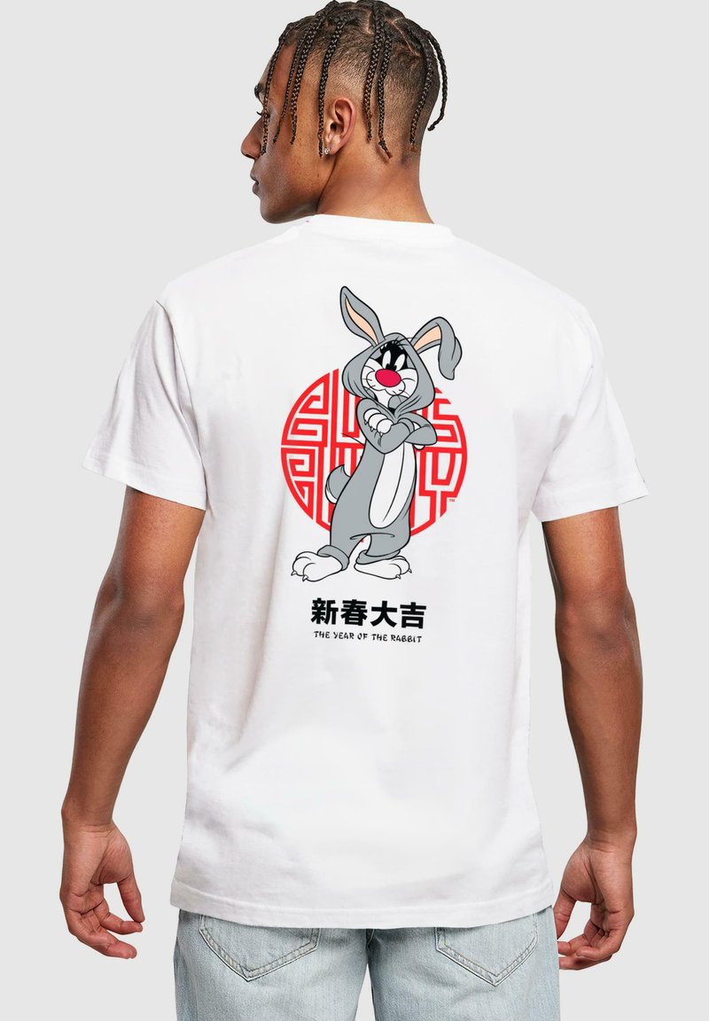 Tricou alb din bumbac cu un design de iepure cartoon pe spate, cu accente circulare roșii și text chinezesc dedesubt.