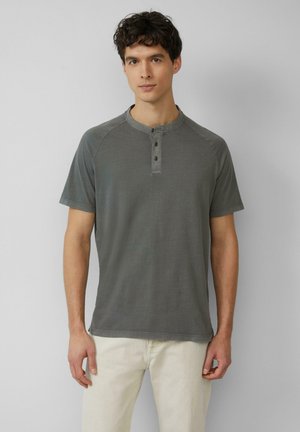 Grijze T-shirt met korte mouwen en een ronde halslijn, drie knopen aan de voorkant en contrasterende stiksels. De stof ziet er glad en zacht uit.