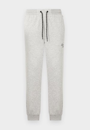 Helehallid dressipüksid mustade paeltega, elastse vöökohaga, mansettidega sääreotstes ja väike must tekst reie ülaosas.