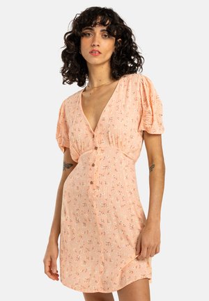Short-sleeve, pink dress featuring a v-neck, button detail, and floral print on textured fabric, falling above the knees.