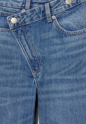 Jeans in denim blu con tasche frontali, taschino appuntito per monete, passanti per cintura e chiusura con bottone metallico con dettagli di cucitura visibili.