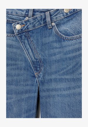 Jeans in denim blu con tasche frontali, taschino appuntito per monete, passanti per cintura e chiusura con bottone metallico con dettagli di cucitura visibili.