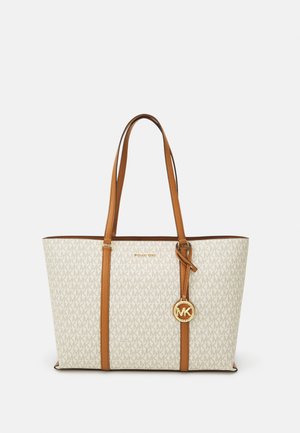 White tote bag with beige monogram pattern, brown leather accents, dual handles, and a gold logo charm attached.