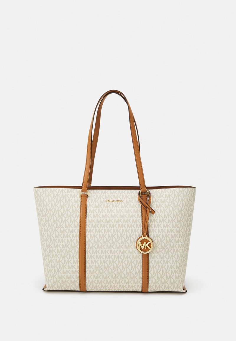 Sac fourre-tout blanc avec motif monogramme beige, accents en cuir marron, double poignées et un charme logo doré attaché.