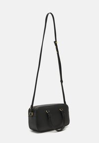 Borsa a tracolla nera in pelle con finitura texture, chiusura con zip, due manici superiori e una lunga tracolla regolabile. Accenti in metallo dorato.