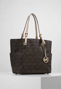 Borsa a tracolla marrone con motivo, dotata di due manici superiori, hardware in oro e un distintivo charm con logo. Presenta tasche esterne e una forma strutturata.