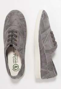 Sneakers in tela grigia con finitura testurizzata, punta rotonda e suola in gomma bianca. Presentano chiusura con lacci e branding ecologico all'interno.