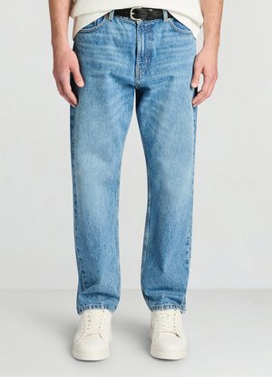 Jeans azzurri chiaro con vestibilità rilassata e design classico a cinque tasche, caratterizzati da cuciture visibili e una texture liscia. Indossati con scarpe da ginnastica bianche.