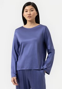 Paarse langemouwtop met een ronde hals en een zachte, gladde textuur. Onderdeel van een bijpassende loungewear set, met een ontspannen pasvorm en een minimalistisch ontwerp.