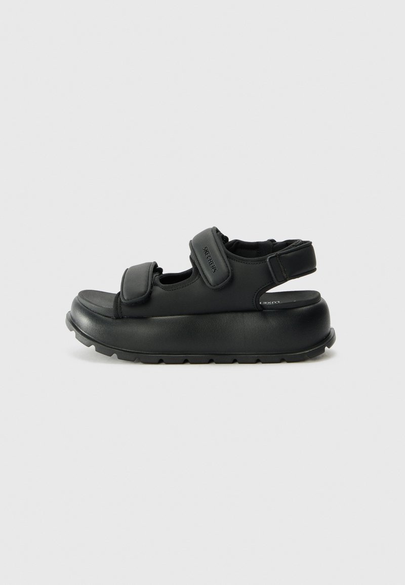 Sandali con piattaforma neri dotati di due cinturini in velcro regolabili, una soletta imbottita e una suola in gomma texturizzata per una buona aderenza.