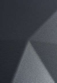 Superficie nera testurizzata con sottili linee orizzontali, caratterizzata da riflessi di luce variabili e da una lucentezza sottile, che enfatizzano la profondità e il motivo.