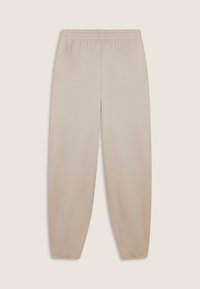 Pantalones de chándal beige con un corte relajado, cinturilla elástica y puños elásticos. Presentan una textura suave, diseño simple y sin bolsillos visibles.