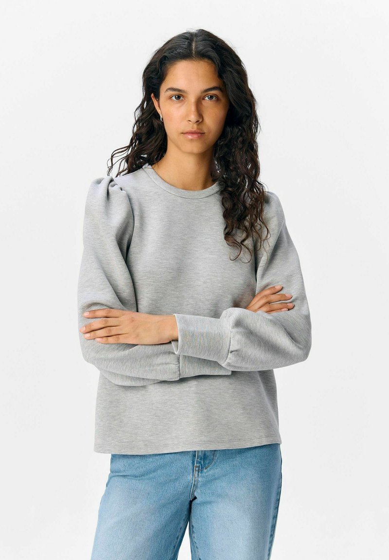 Grijze sweatshirt met uitstaande mouwen, ronde hals en geribde manchet. Draag het met lichtblauwe jeans, wat zorgt voor een relaxte pasvorm en zachte textuur.