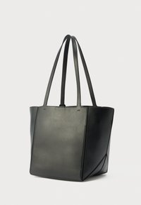 Sac fourre-tout en cuir noir avec deux longues anses, forme rectangulaire, texture lisse et coutures minimalistes. Présente une silhouette structurée.