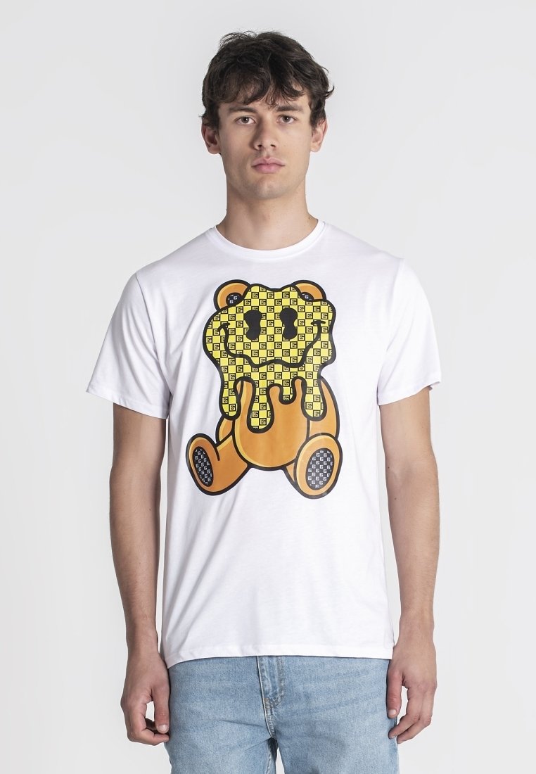 Camiseta de algodón blanca con un diseño de oso de dibujos animados y un patrón amarillo que gotea. Manga corta y cuello redondo.