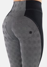 Leggings a vita alta con un motivo a scacchiera nero e grigio, pannelli laterali neri solidi, texture liscia e dettaglio con logo.