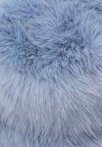 Tessuto in pelliccia sintetica di un soffice azzurro chiaro, caratterizzato da una consistenza morbida con lunghe ciocche e una leggera lucentezza.