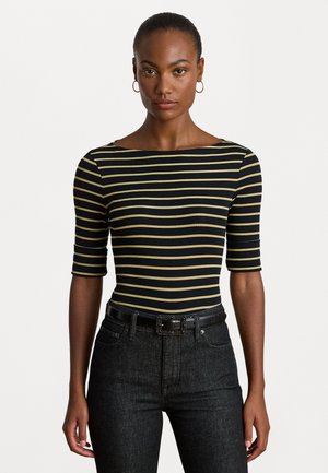 Top aderente a righe nero e giallo con maniche corte e scollatura ampia, abbinato a jeans in denim scuro e una cintura nera.