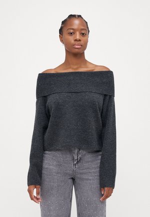 Dark gray off-the-shoulder sweater with ribbed neckline, long sleeves, and a soft textured finish, paired with light gray jeans.