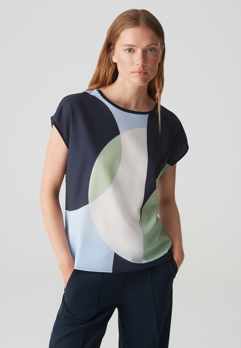 Top a maniche corte blu navy con motivo geometrico in azzurro chiaro, verde e crema. Tessuto morbido con una vestibilità rilassata.