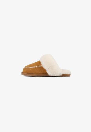 Bruine suede pantoffel met een fluffy crèmekleurige leren band, platte zool en decoratieve witte stiksels langs de randen.