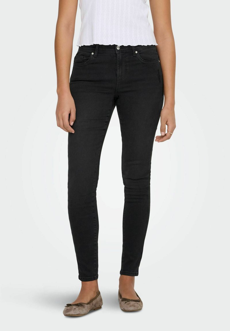 Mustad kõrge vöökohaga kitsad teksad, valmistatud teksariidest, klassikalise viiepokilooga ja põlvedel peene tuhmumisega.