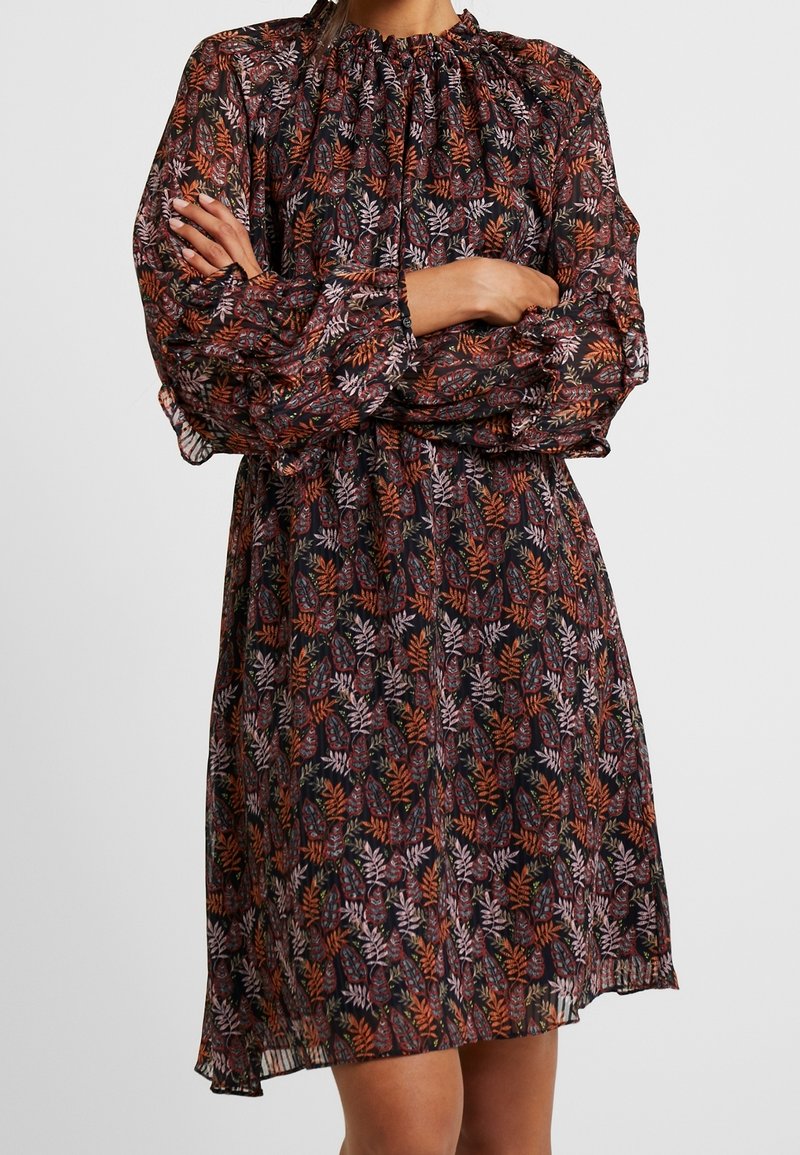 Robe légère à motif floral sur tissu foncé, dotée de manches longues bouffantes, d'un col rond plissé et d'un ourlet mi-long.