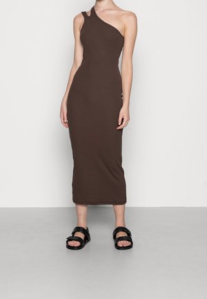 Ruskea, istuva, polvimittainen mekko, jossa on yhden olkapään malli, valmistettu pehmeästä kankaasta. Yhdistetty mustiin, matalapohjaisiin sandaaleihin.