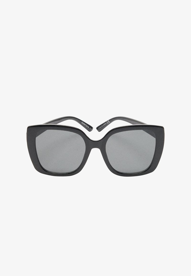 Czarne okulary przeciwsłoneczne z masywną kwadratową oprawką i szarymi szkłami. Zauszniki są smukłe o połyskującym wykończeniu. Charakterystyczne dzięki swojemu geometrycznemu wzornictwu.