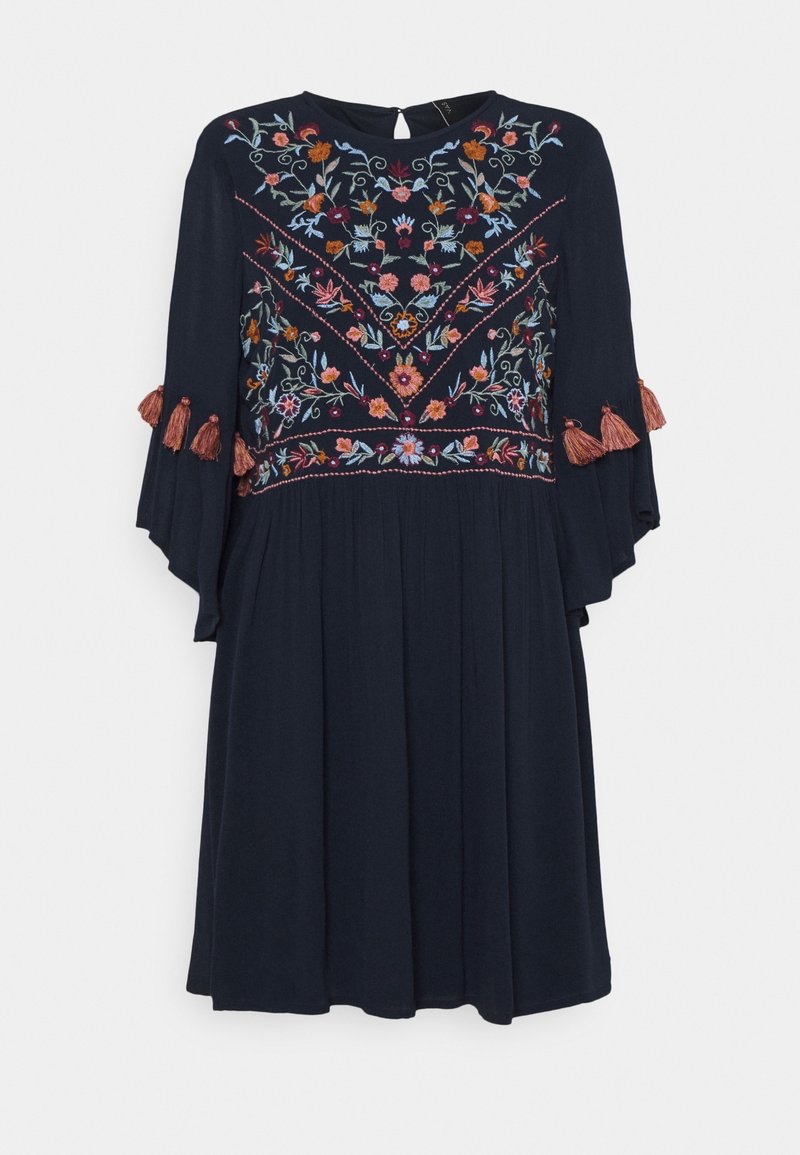 Robe bleu marine avec broderie florale colorée sur le buste et les manches, manches évasées ornées de pampilles couleur rouille, longueur genou, encolure ronde.