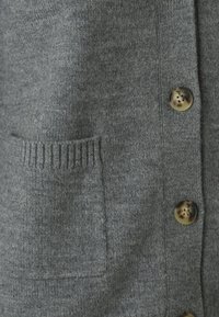 Grauer gestrickter Cardigan mit Knopfverschluss, gerippten Taschen und braun gefärbten Knöpfen, der eine weiche Textur und Wärme betont.