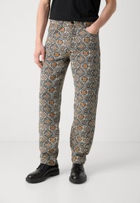 Mønstrede bukser lavet af stof med orange blomsterdesigns på en sort baggrund, med lige pasform og almindelige lommer.