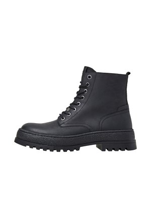 Botas de cuero negro hasta el tobillo con una suela de plataforma texturizada, parte frontal con cordones y ojales de metal. Cuenta con una lengüeta en la parte trasera para facilitar su uso.