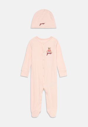 Body bébé rose avec boutons à l'avant, ours en peluche et broderie "guess", assorti d'un chapeau rose assorti avec le texte "guess".