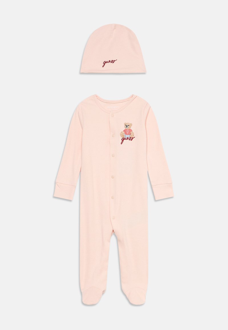 Body bébé rose avec boutons à l'avant, ours en peluche et broderie "guess", assorti d'un chapeau rose assorti avec le texte "guess".