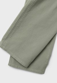 Tessuto in cotone twill verde con una finitura testurizzata, caratterizzato da bordi piegati con cura e cuciture visibili.