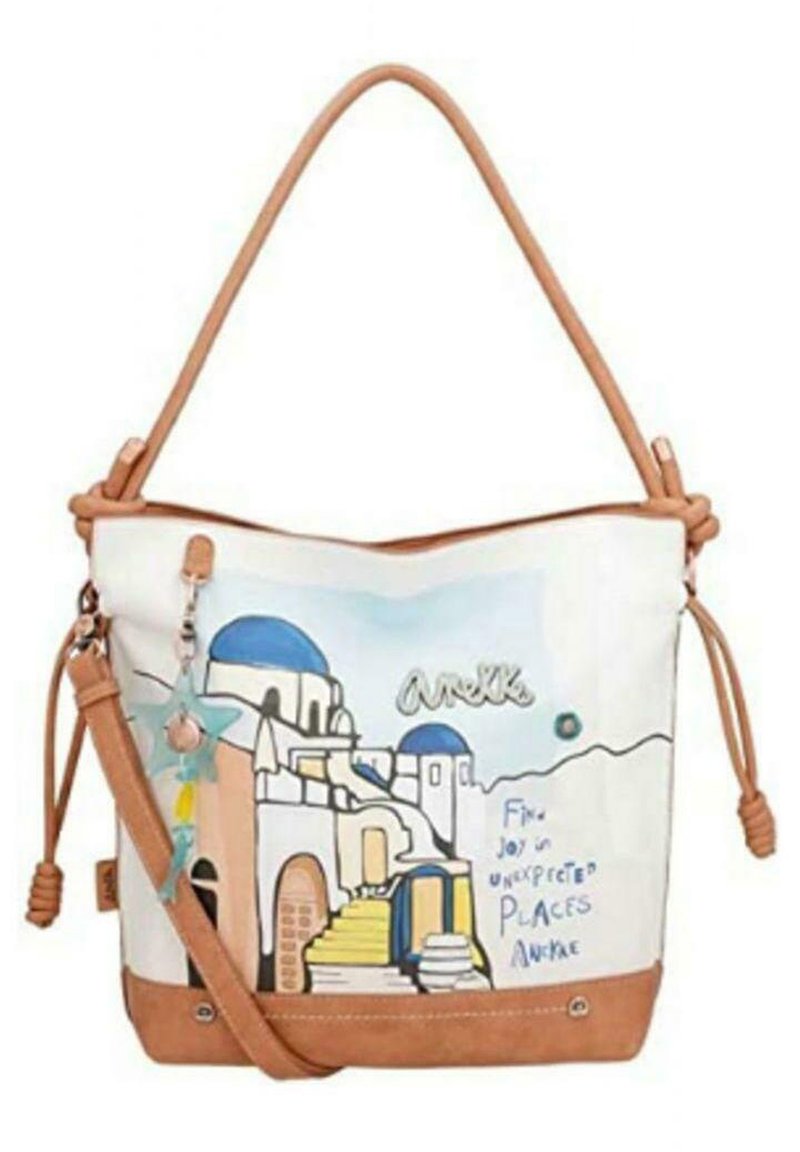 Borsa in morbido tessuto con dettagli in pelle color beige e un design architettonico blu e bianco. Presenta un ciondolo staccabile e una tracolla regolabile.