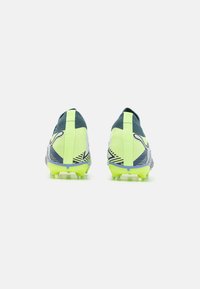 Scarpe da calcio in giallo neon e blu scuro, con una tomaia testurizzata, un design del tallone distintivo e tacchetti modellati per una migliore aderenza.