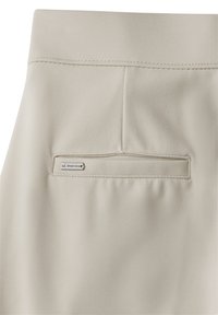 Helle beigere Hose aus glattem Stoff mit einem genähten Bund und einer Gesäßtasche, die mit einem genähten Etikett "E.Street One" versehen ist.