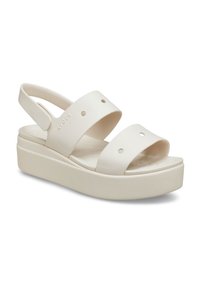 White platform sandals made of rubber, featuring two wide straps with circular cutouts and a slingback design for secure fit.