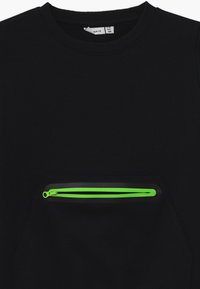 Felpa nera con tasca frontale dotata di una zip verde brillante. Il tessuto è liscio e elasticizzato, con colletto rotondo e polsini a costine.