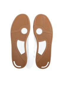 Fehér sportcipők barna gumitalppal, halszálka mintával és kerek díszítésekkel. A márkajelzés látható az oldalsó panelekon.