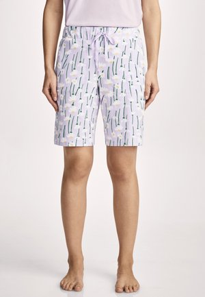 Person trägt helllila knielange Shorts mit weißem Gänseblümchen- und grünem Stängelmuster sowie einem passenden Tunnelzugbund.