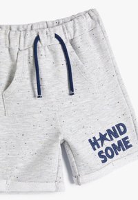 Grå shorts med en tekstureret stof, udstyret med marineblå snore, to sidelommer og ordet "HAND" med en stjerne og "SOME" broderet i marineblå.