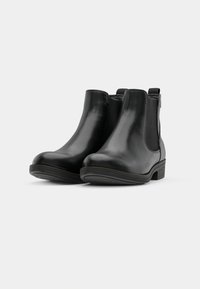 Svarta läderankelstövlar med rund tå, elastiska sidopaneler, dragflik och en låg, texturerad gummisula.